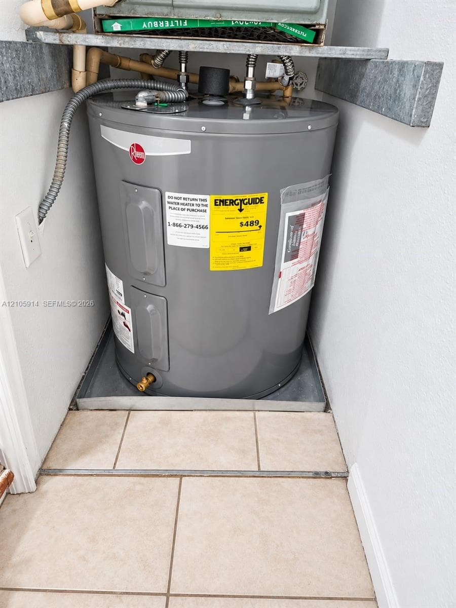 Electric water heater unit situated within a tiled containment pan