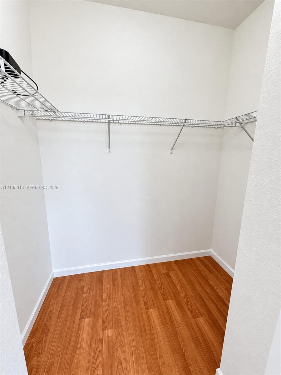 Storage area featuring wood-finish flooring and integrated wire shelving