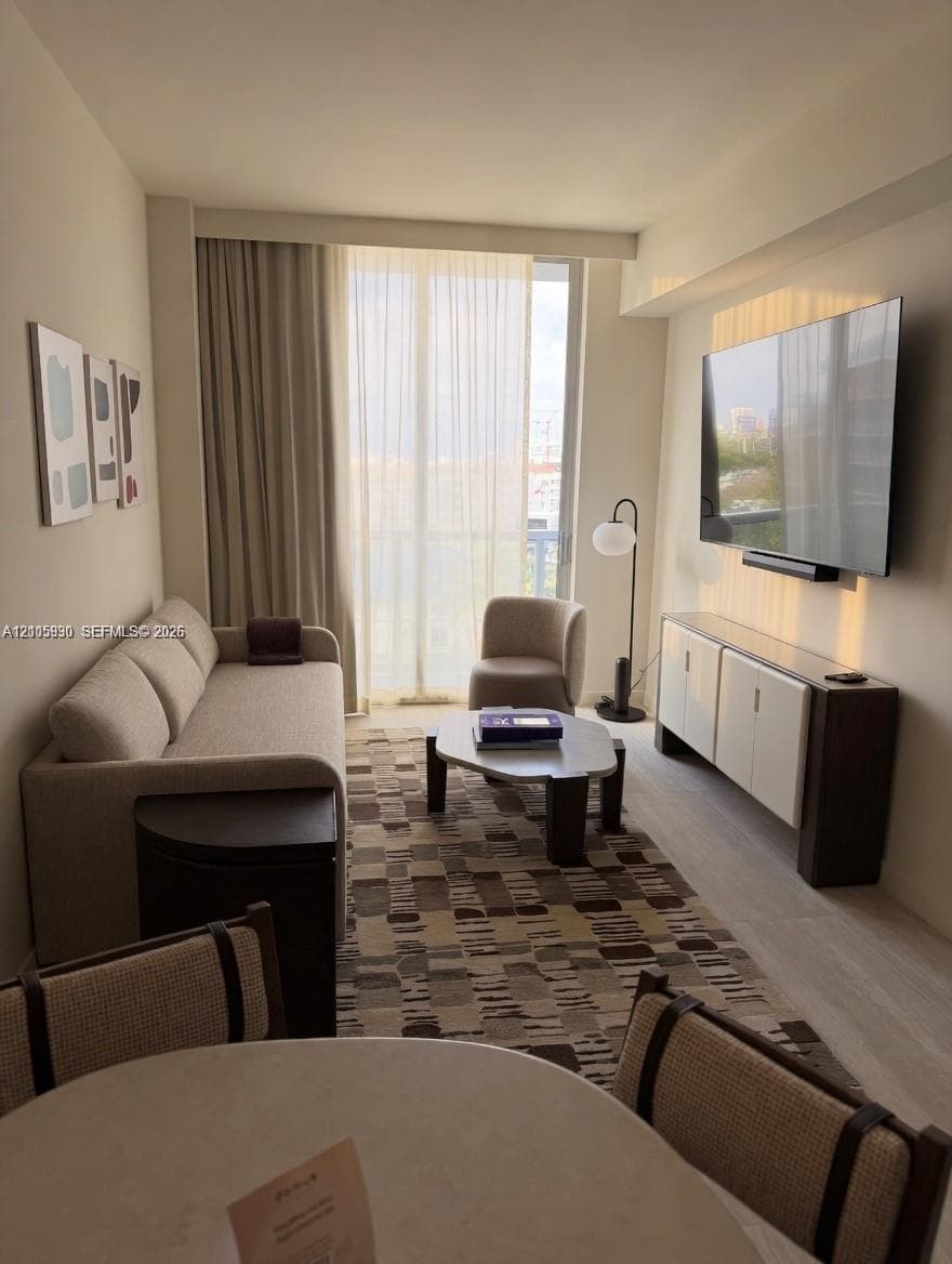 Floor-to-ceiling sliding glass doors, neutral interior palette, and light-toned wood-finish flooring