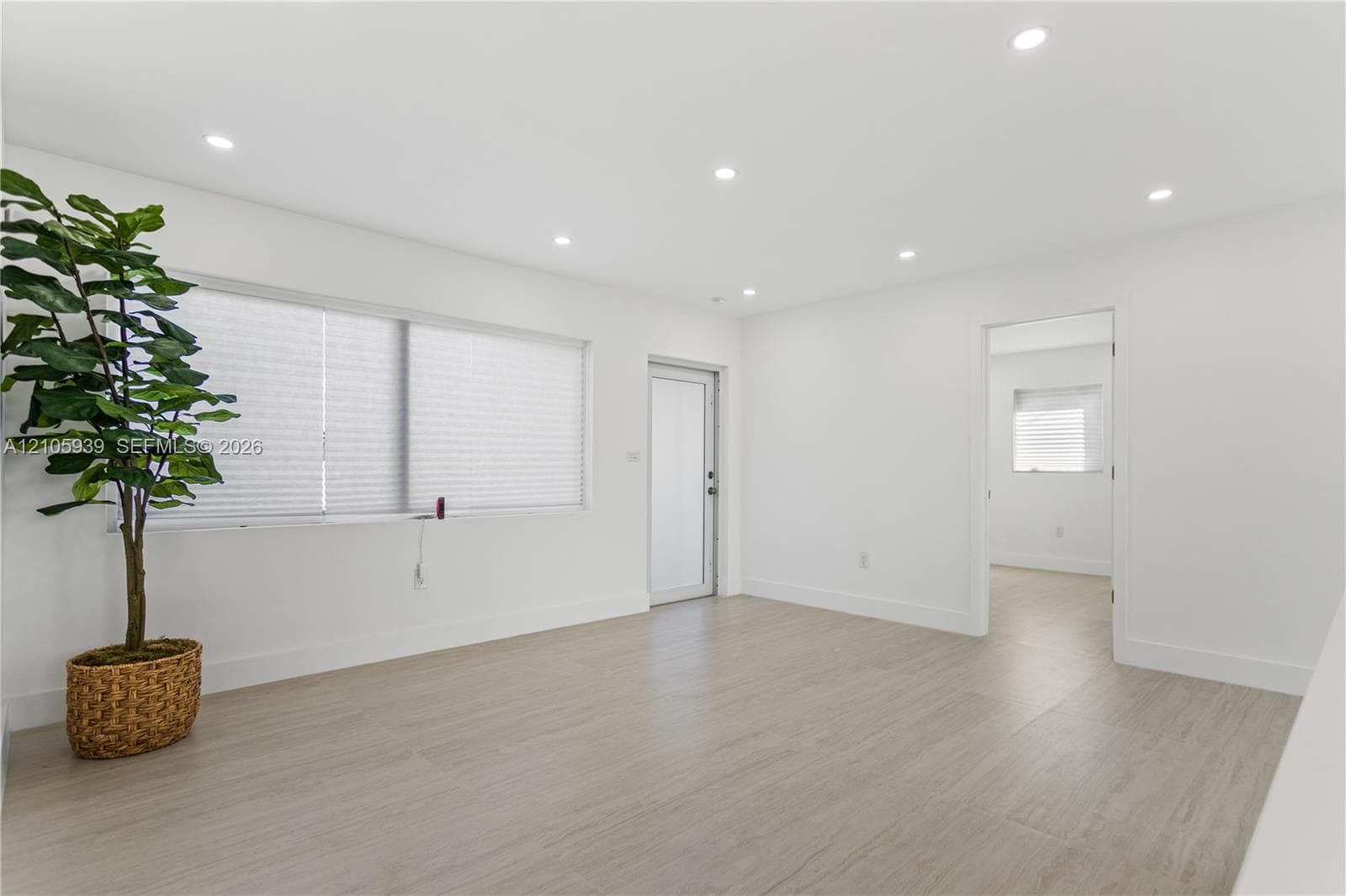 Interior room featuring wood-finish flooring, recessed lighting, and a frosted glass exterior door