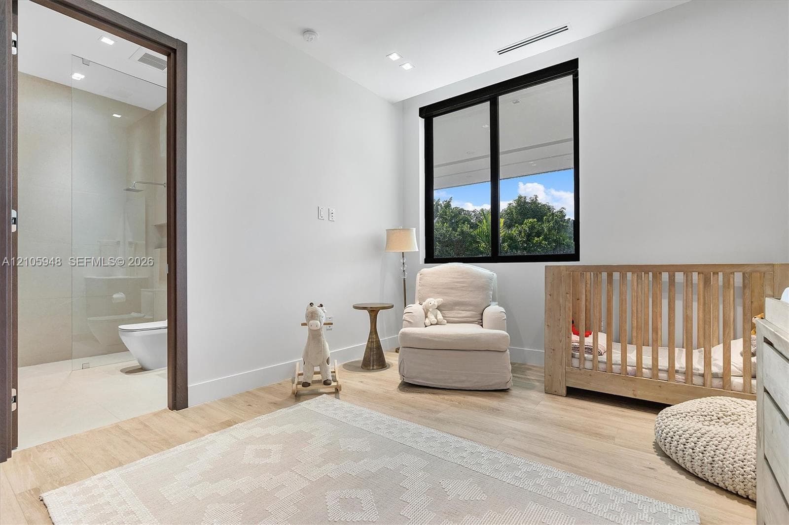 Light-filled room featuring wood-finish flooring, recessed lighting, and a window with a black frame
