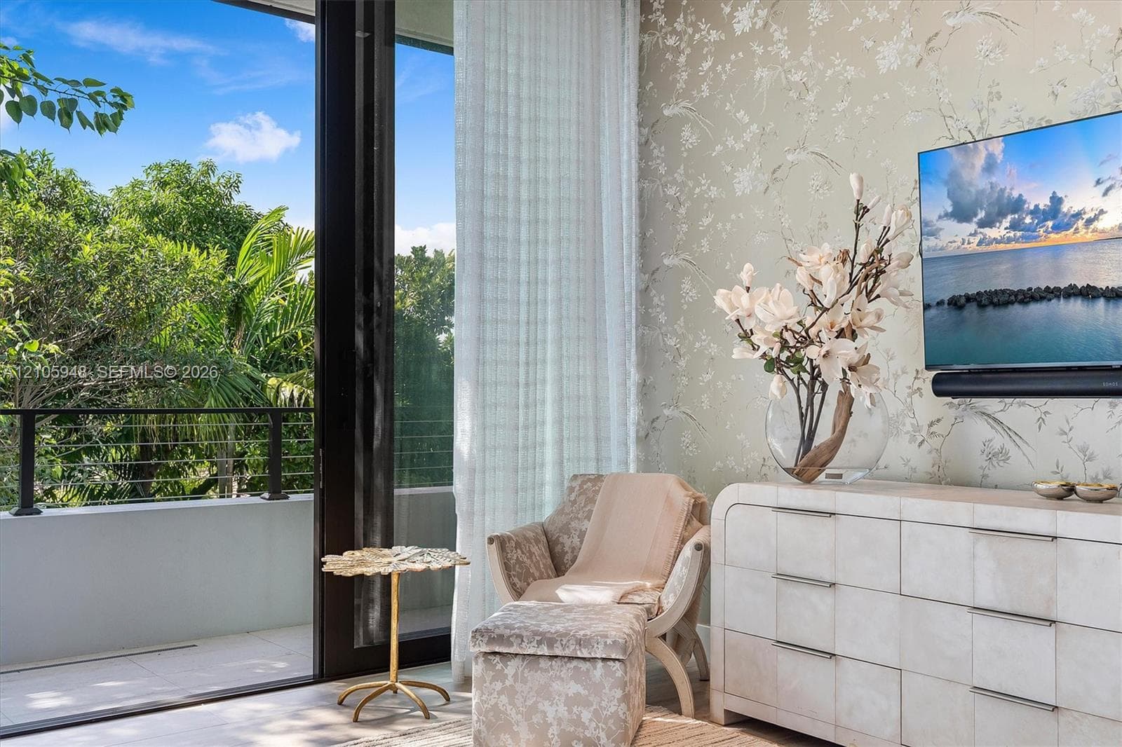 Floor-to-ceiling sliding glass door, metal balcony railing, patterned wallpaper, and large-format tile flooring
