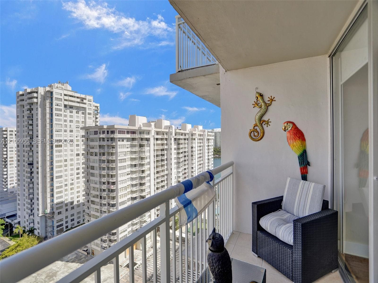 Covered balcony featuring white metal railings and tiled flooring