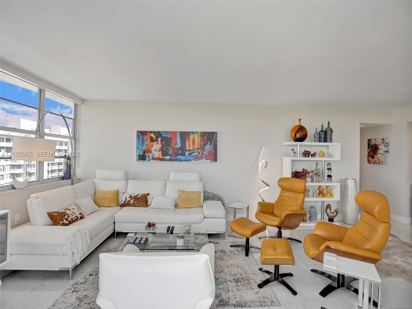 Living area featuring expansive floor-to-ceiling windows and large-format tile flooring
