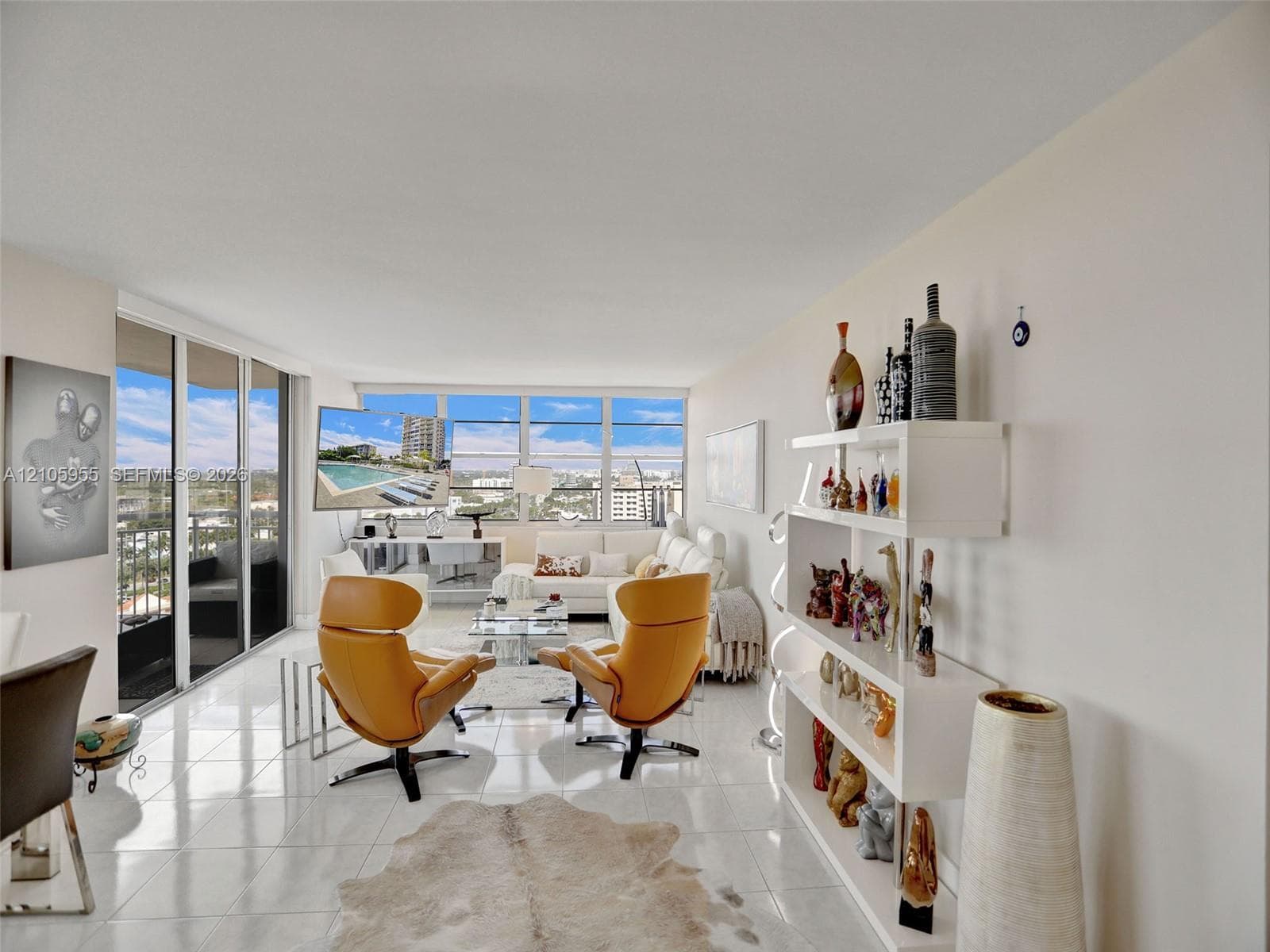 Expansive living space featuring polished tile flooring, floor-to-ceiling windows, and access to a private balcony