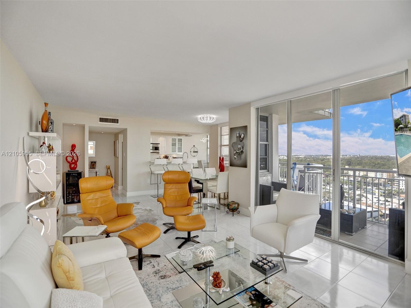 Open-concept interior featuring large-format tile flooring, recessed lighting, expansive floor-to-ceiling glass sliding doors, and a built-in refrigerated wine storage unit