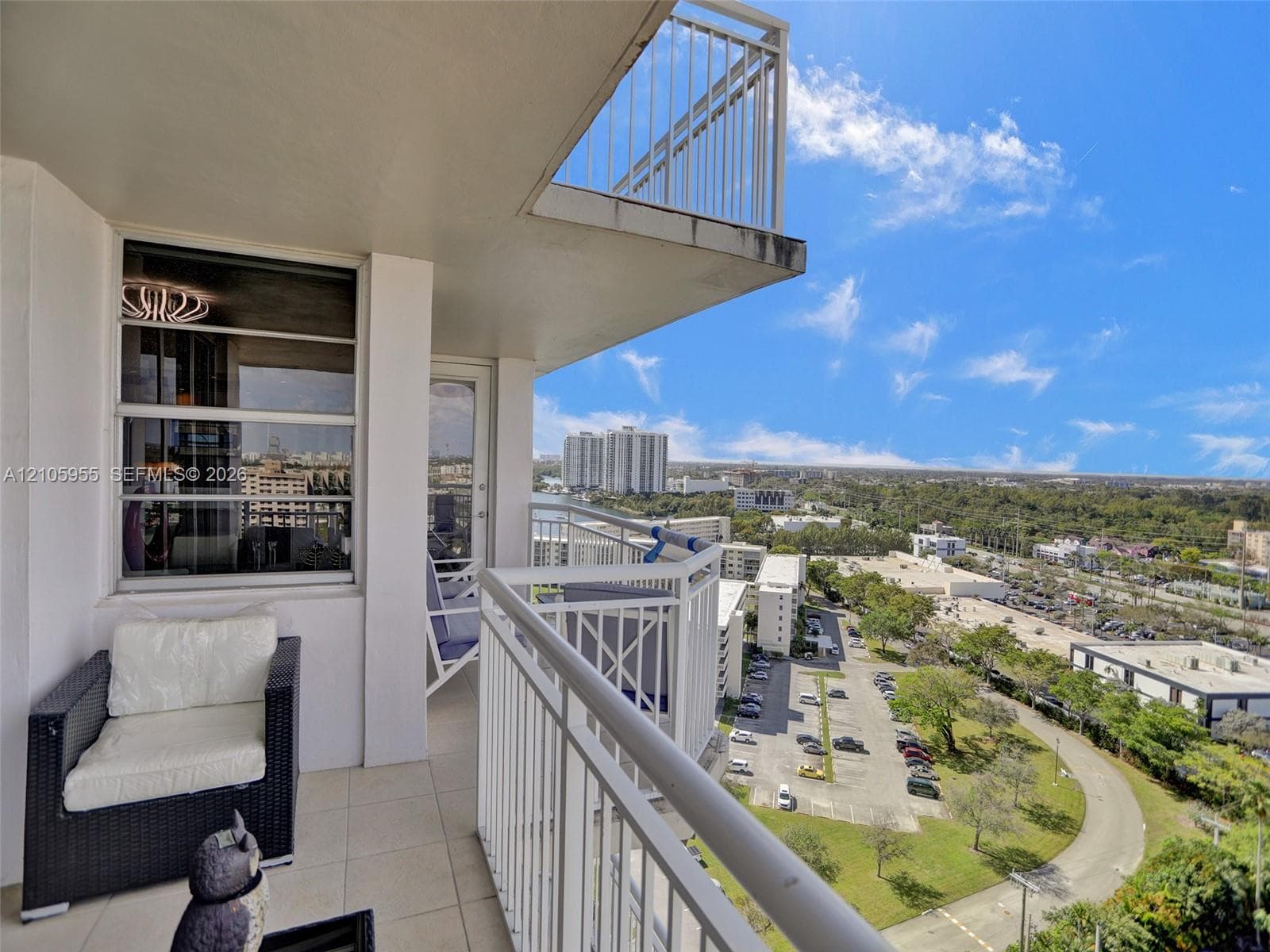 Covered balcony with white metal railings and tile flooring