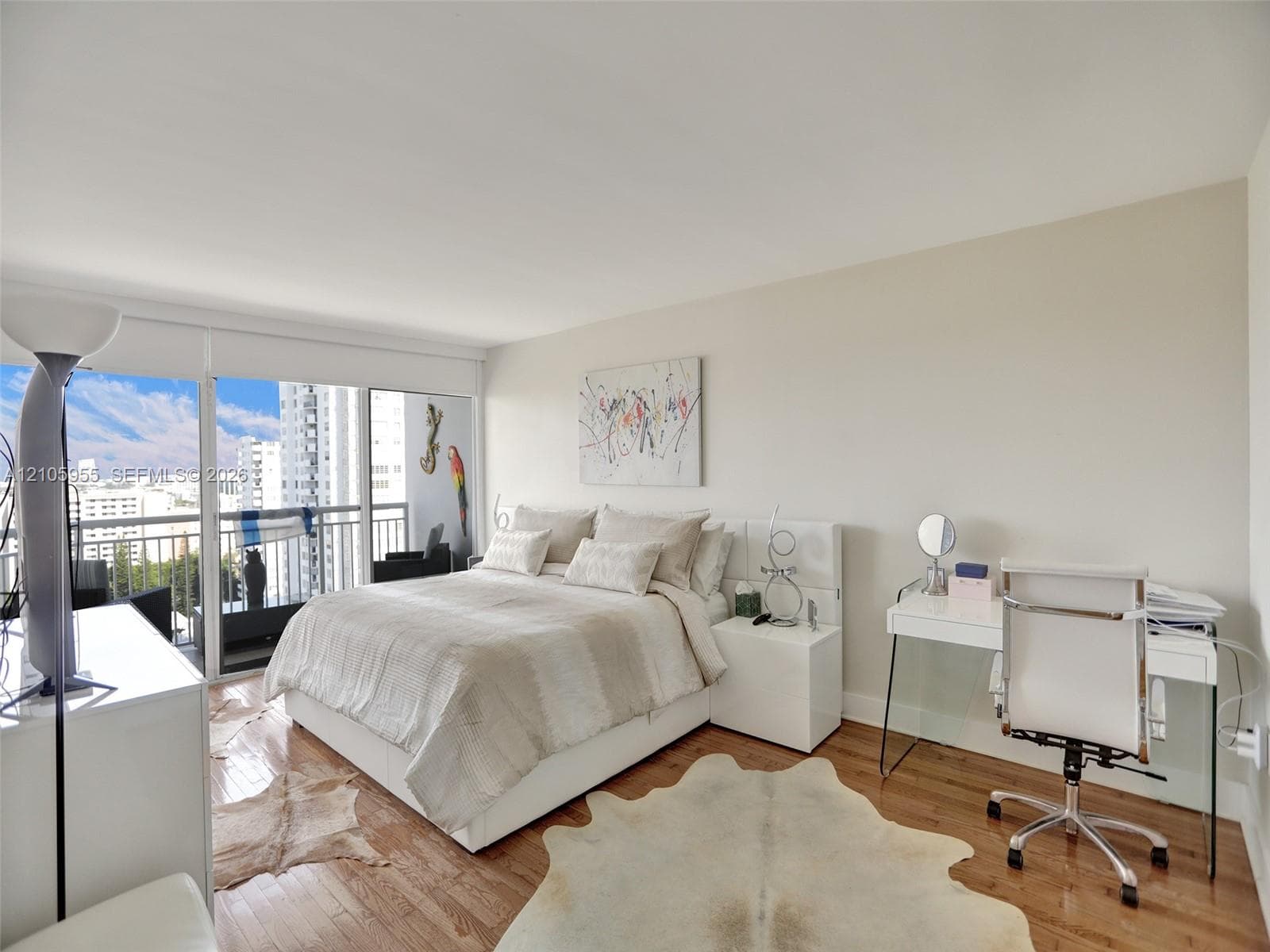 Wood-finish flooring, floor-to-ceiling glass sliding doors, and private balcony with metal railing
