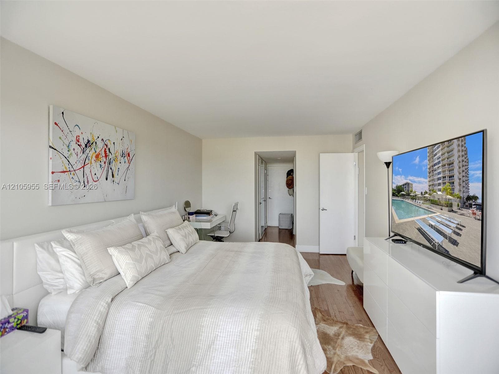 Neutral-toned bedroom featuring hardwood flooring and solid-core interior doors