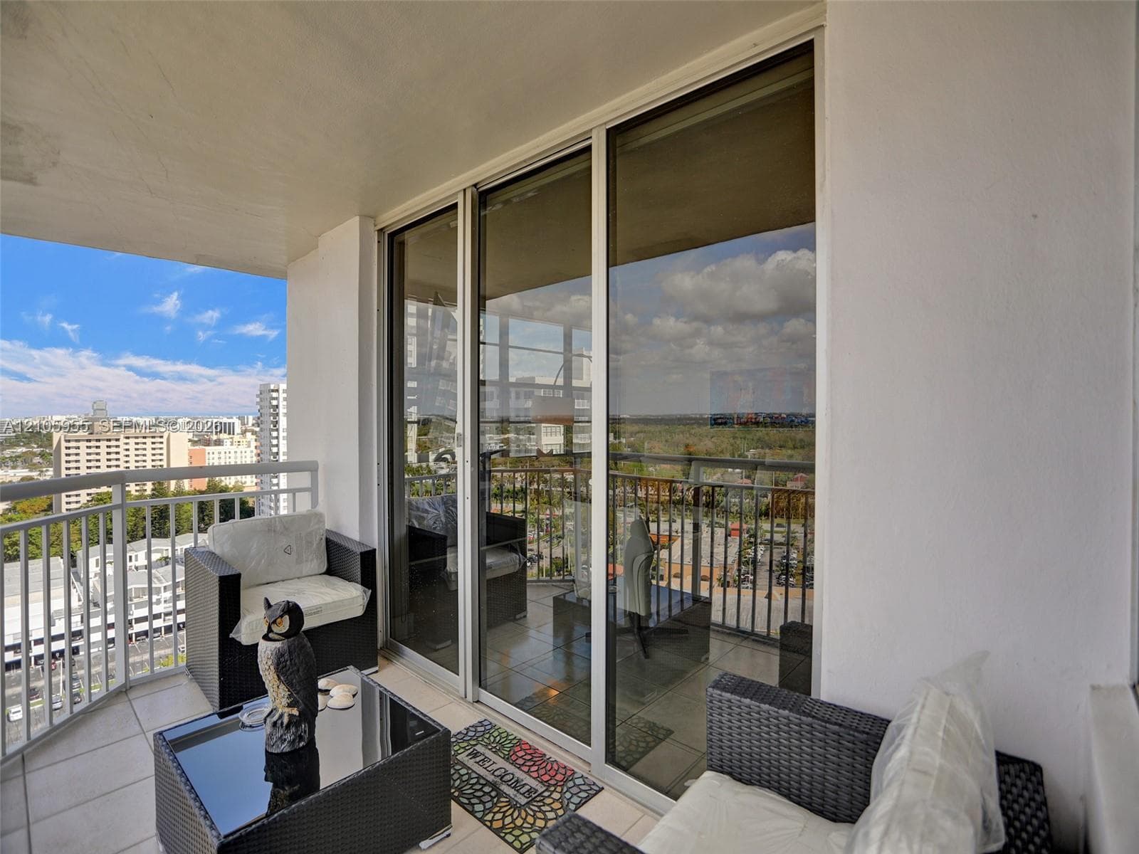 Private balcony featuring large-format tile flooring, metal railings, and full-height sliding glass doors