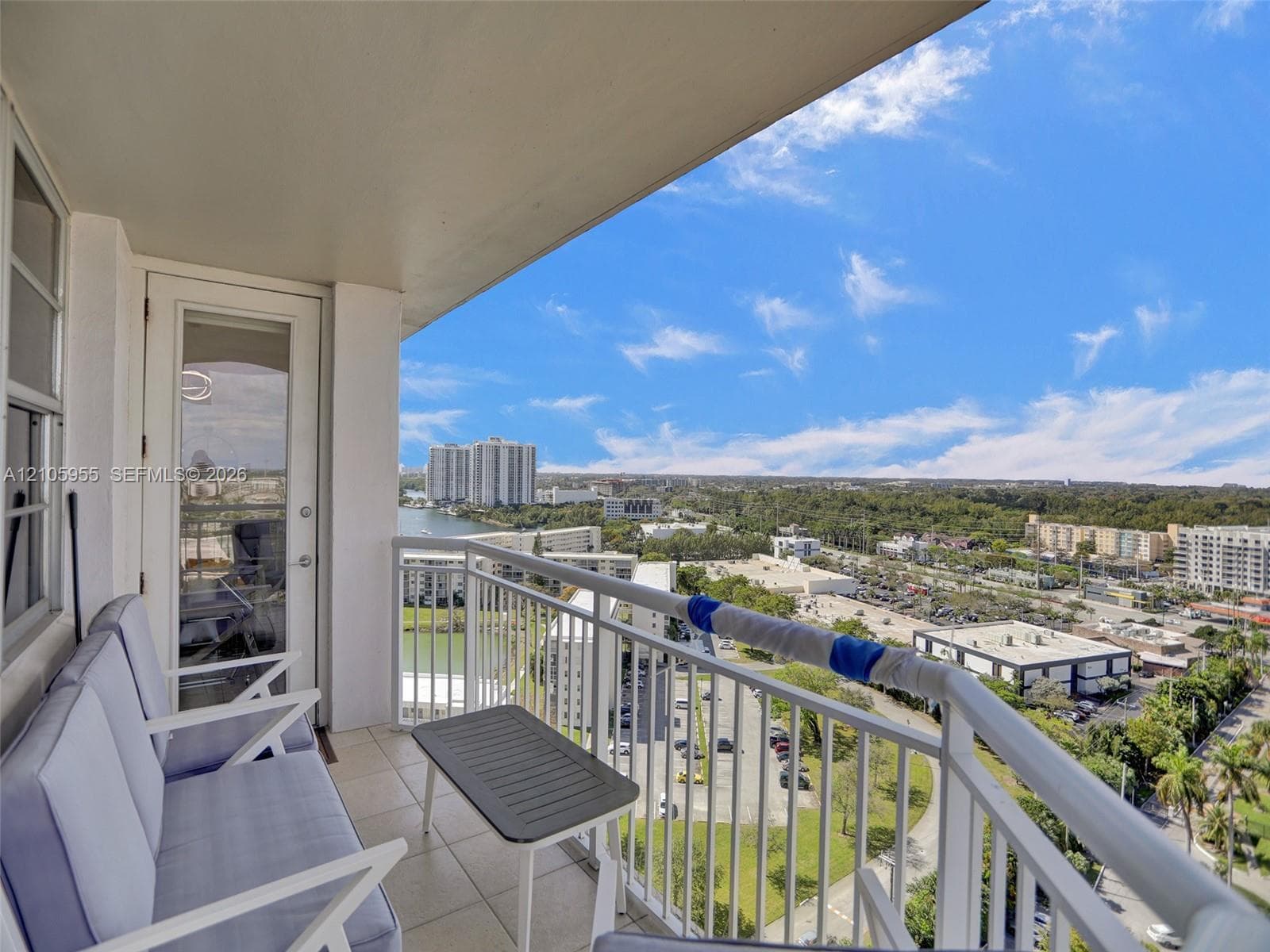 Covered balcony featuring tile flooring and white metal railing
