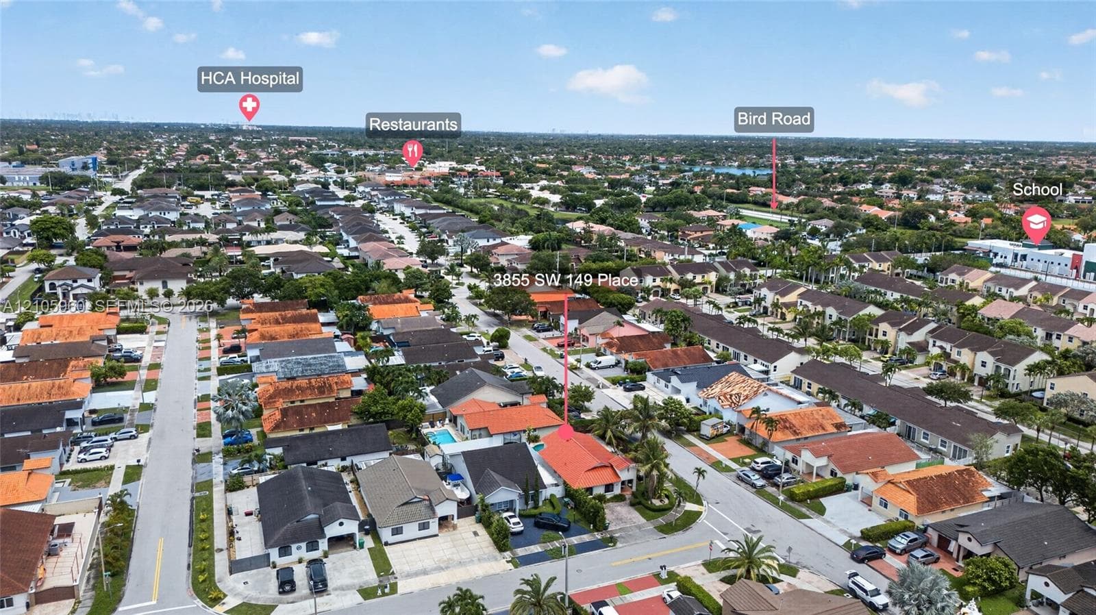 Aerial perspective of residential property featuring a clay tile roof, a private swimming pool, and a paved driveway