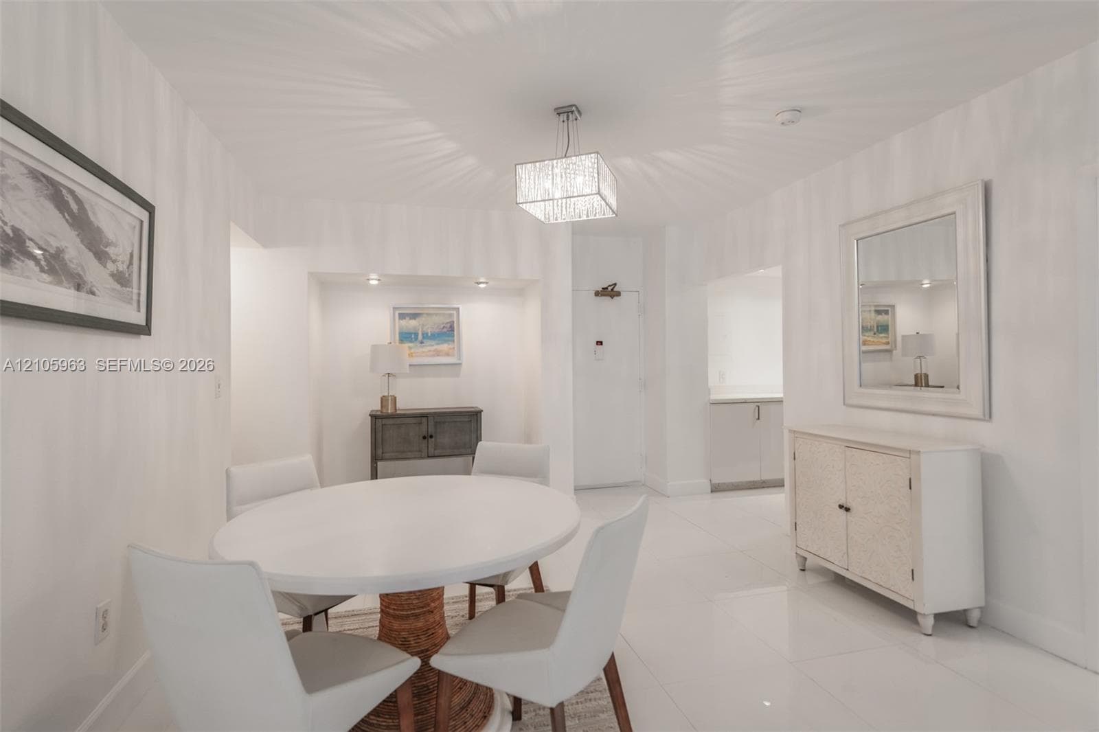 Formal dining area featuring large-format tile flooring, a geometric crystal pendant light, and a recessed wall niche with integrated spot lighting