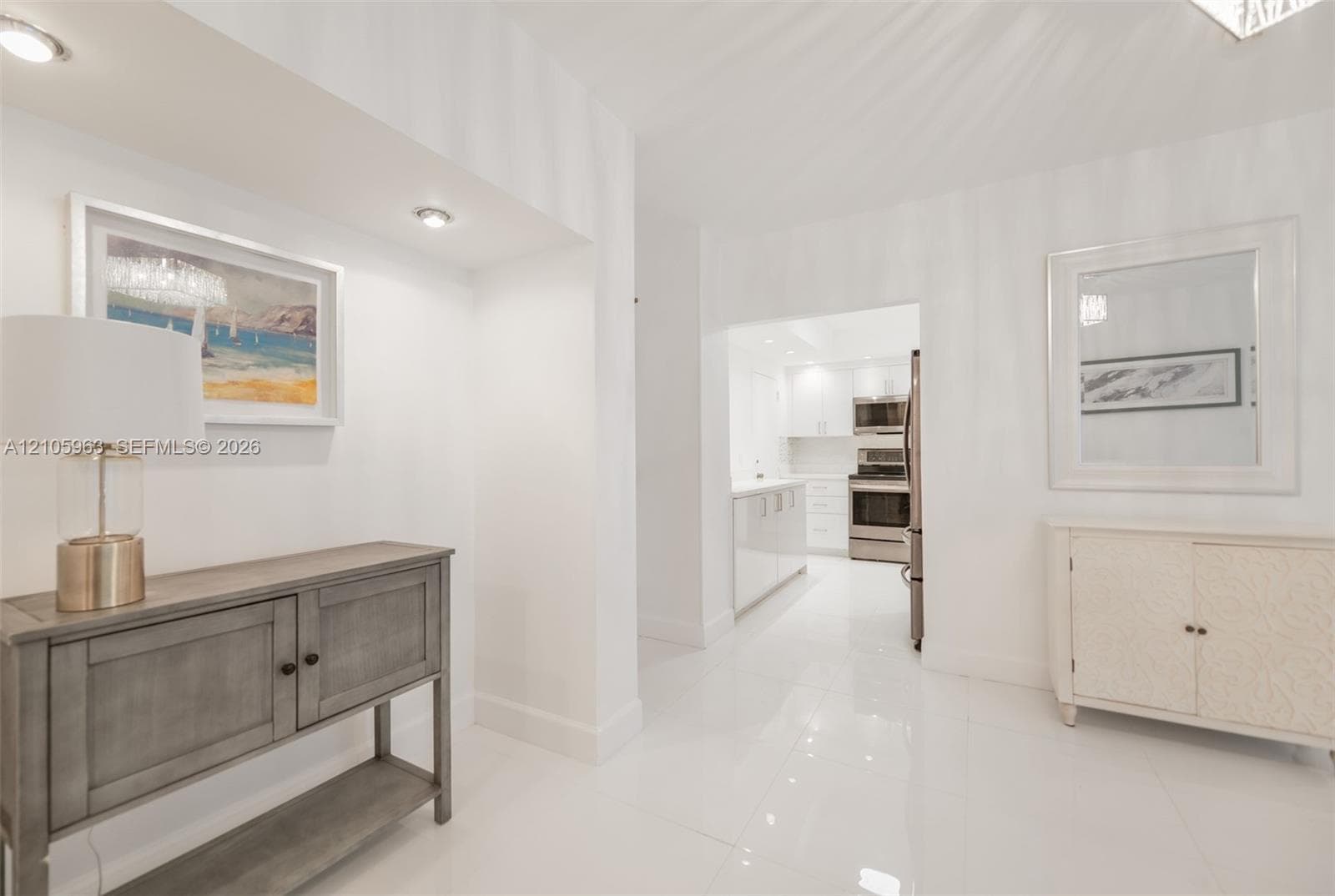 Polished tile flooring, recessed ceiling lighting, and white wall finishes