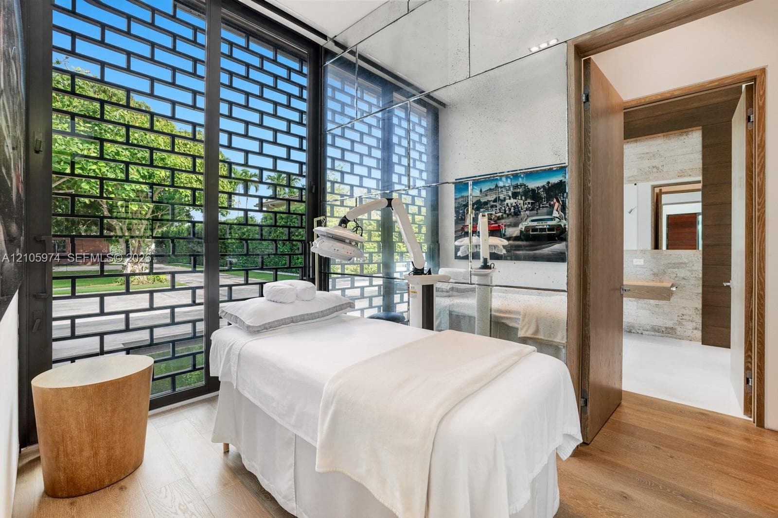Floor-to-ceiling windows with black metal decorative screening, mirror-panel wall cladding, and wood-finish flooring