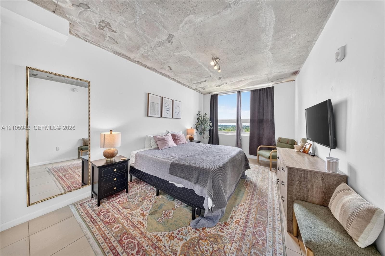 Exposed concrete ceiling, floor-to-ceiling windows, and neutral tile flooring