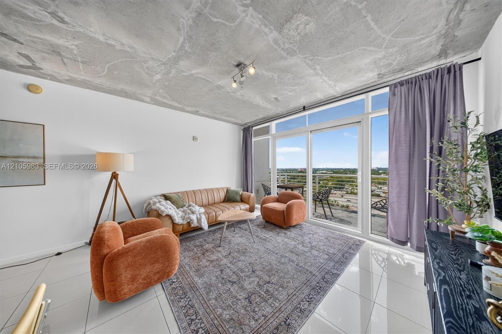 Exposed concrete ceiling, floor-to-ceiling glass wall, polished large-format tile flooring, and attached exterior balcony