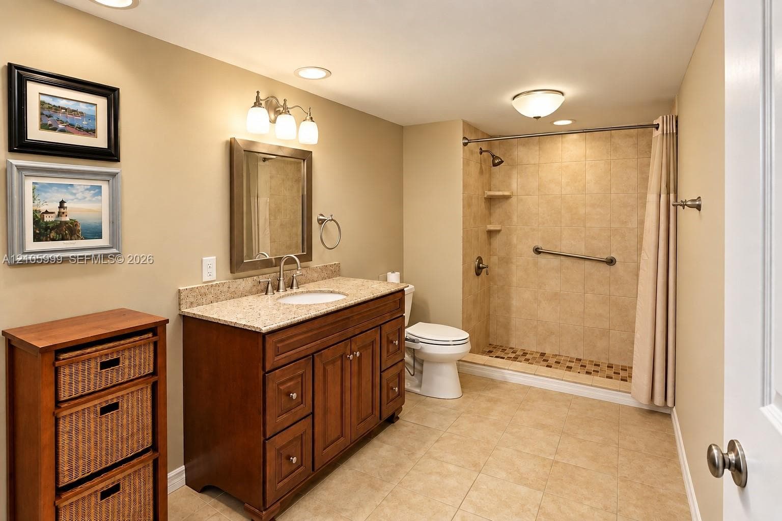 Bathroom featuring a wooden vanity with a stone countertop, an integrated sink, a walk-in shower with tiled walls, and recessed lighting
