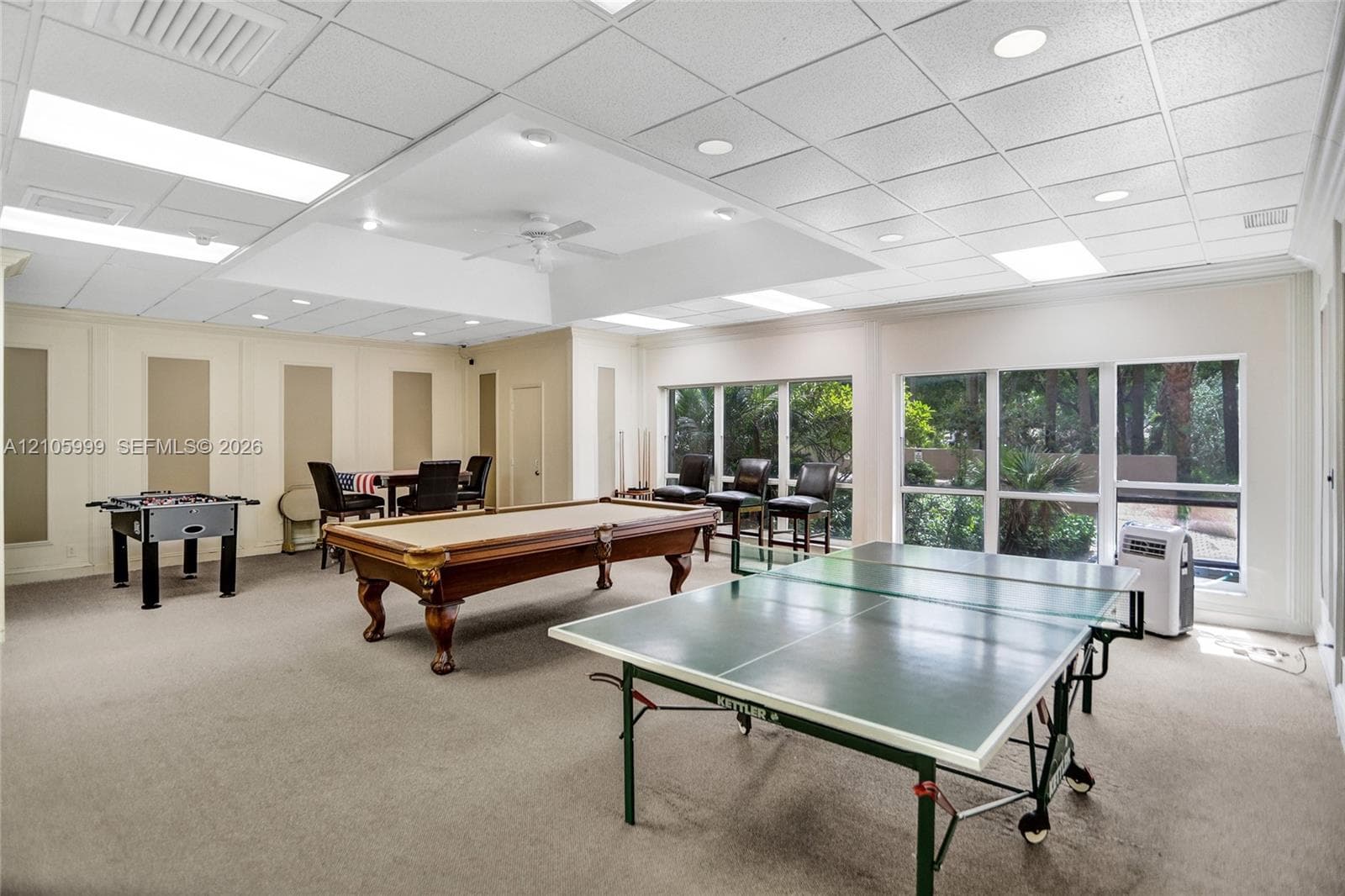 Expansive interior space featuring a recessed tray ceiling, integrated recessed lighting, and wall-to-wall carpeting
