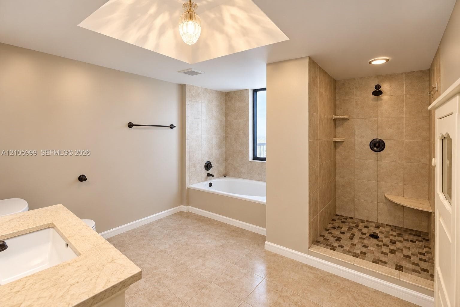 Bathroom featuring a walk-in shower with mosaic tile flooring, built-in corner bench, soaking tub, stone-surfaced vanity, and recessed ceiling lighting