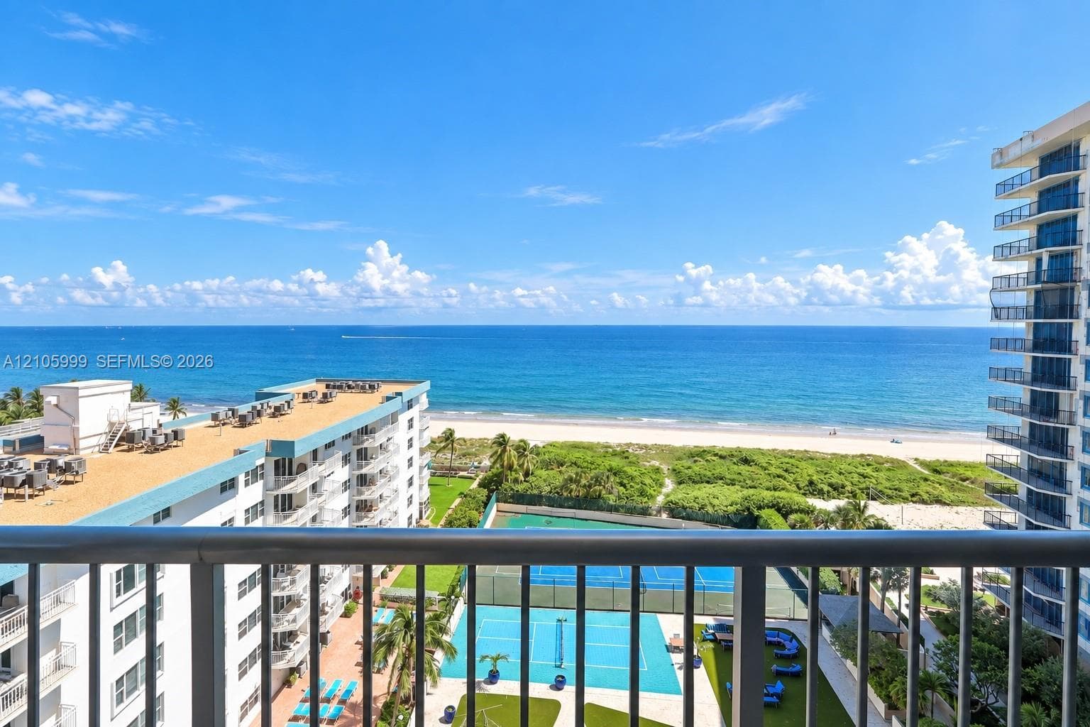 Oceanfront-Private balcony featuring metal railings with a direct perspective of the ocean, shoreline, and on-site tennis courts