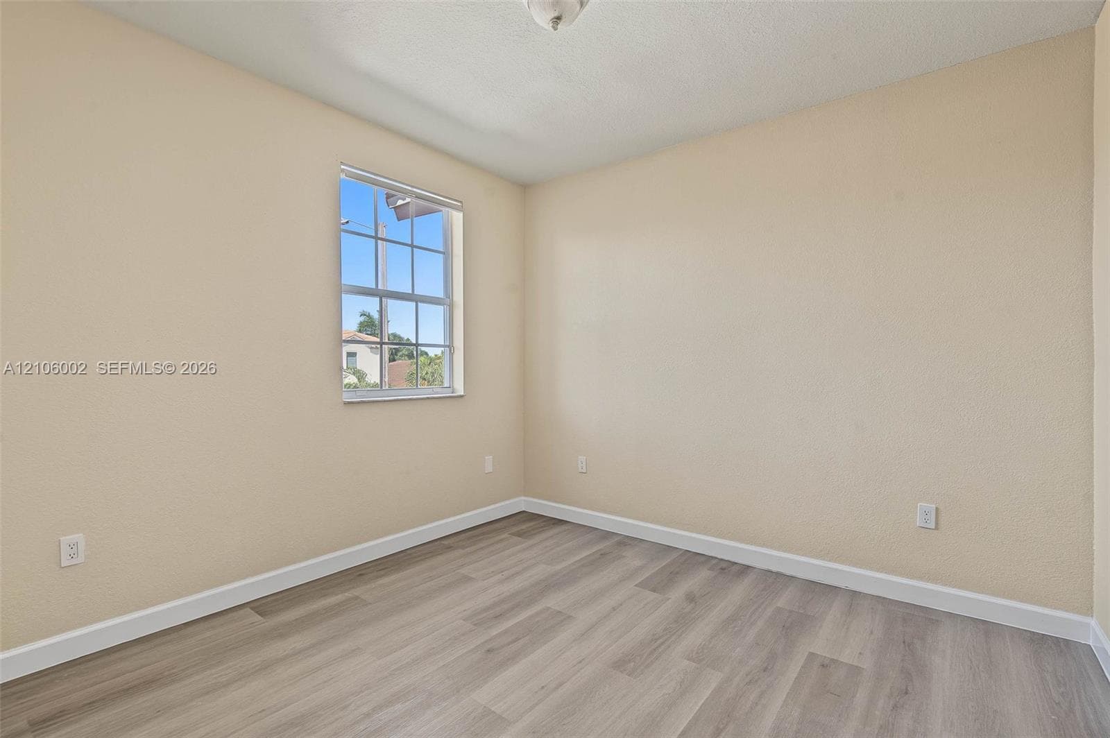 Neutral wall finishes, wood-finish flooring, and a single-hung grid window