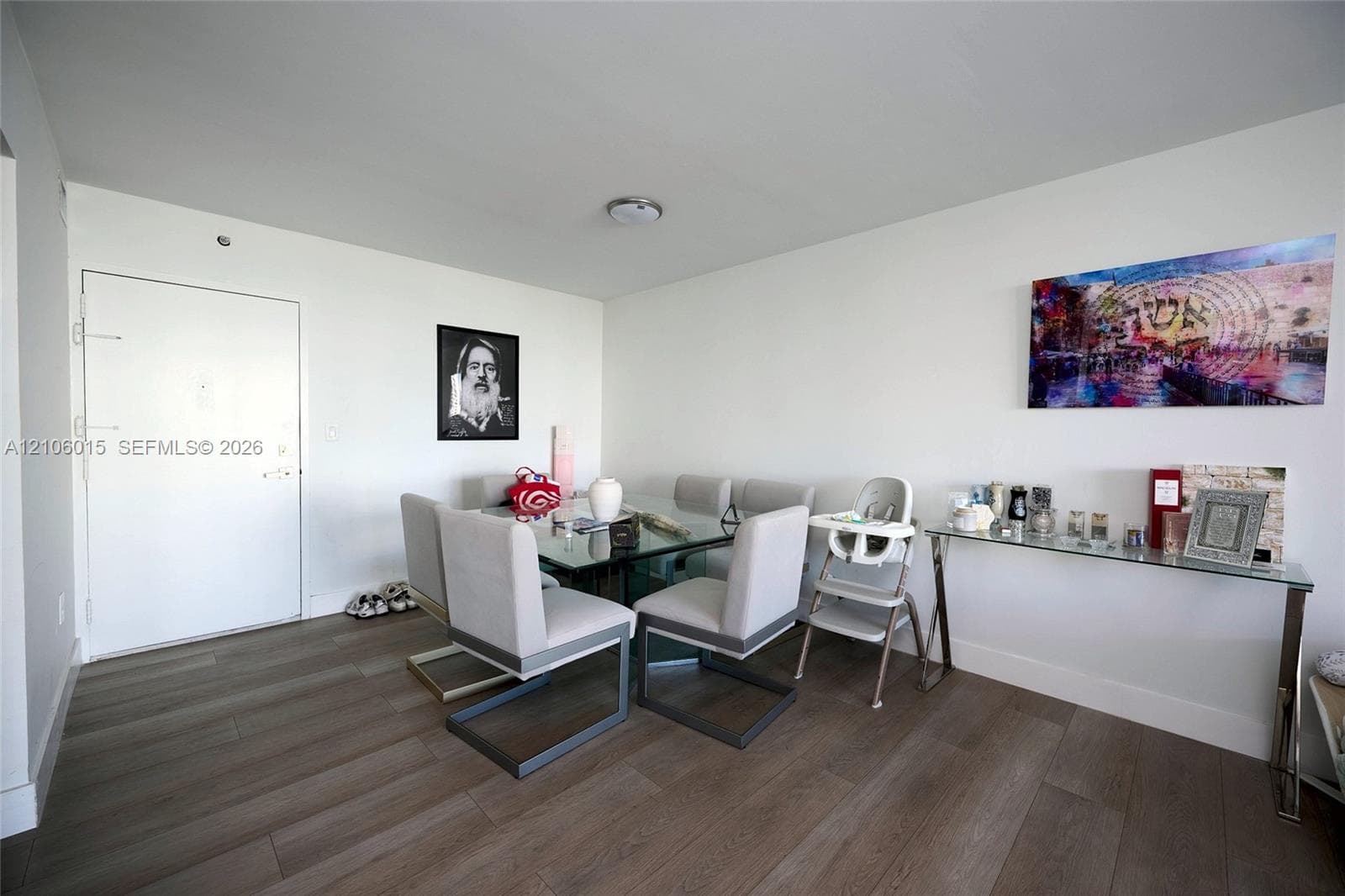 Interior space featuring wood-finish flooring, white walls, and a ceiling-mounted light fixture