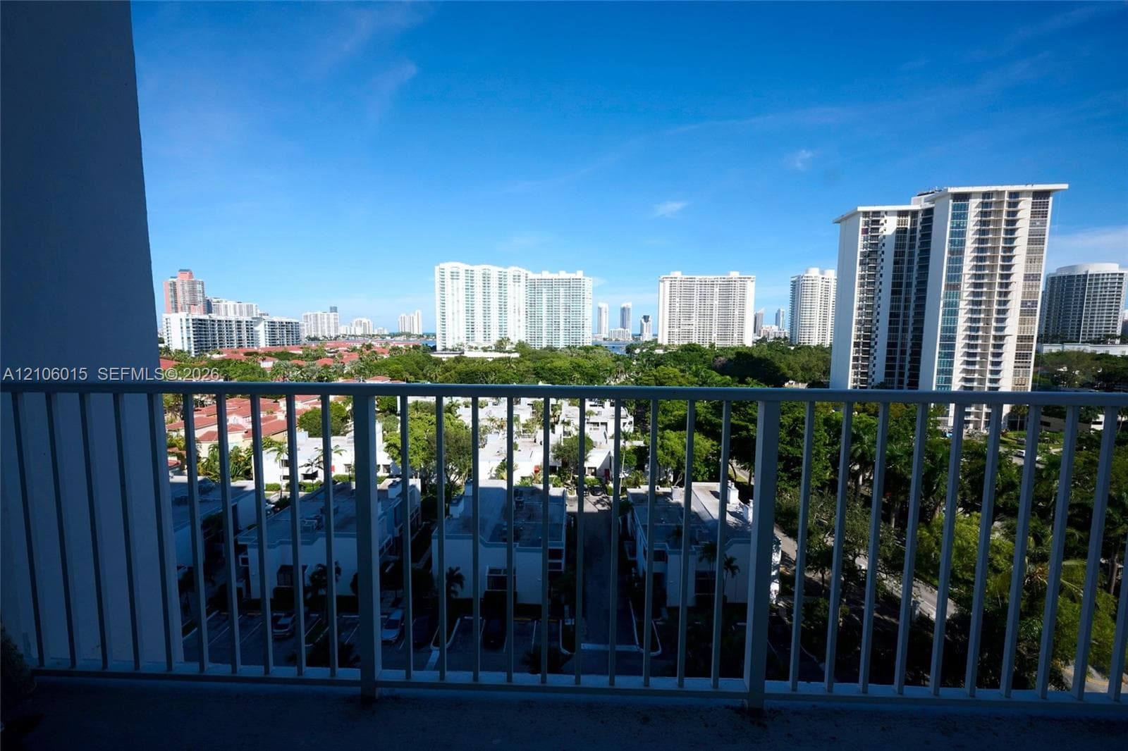 Private balcony featuring vertical metal railings and a cityscape backdrop