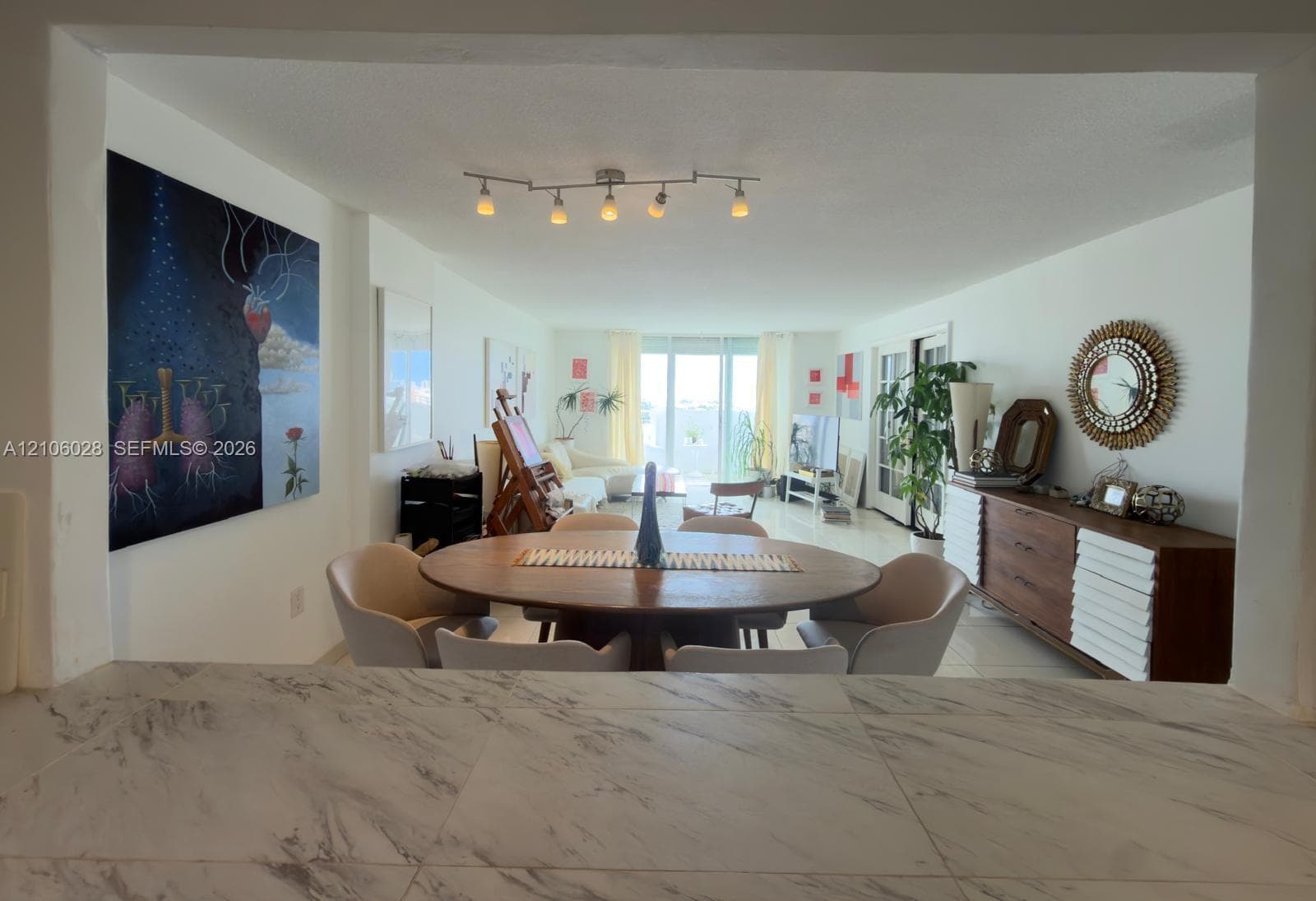 Countertop with a neutral stone-pattern finish, overhead adjustable track lighting, and smooth-finish flooring