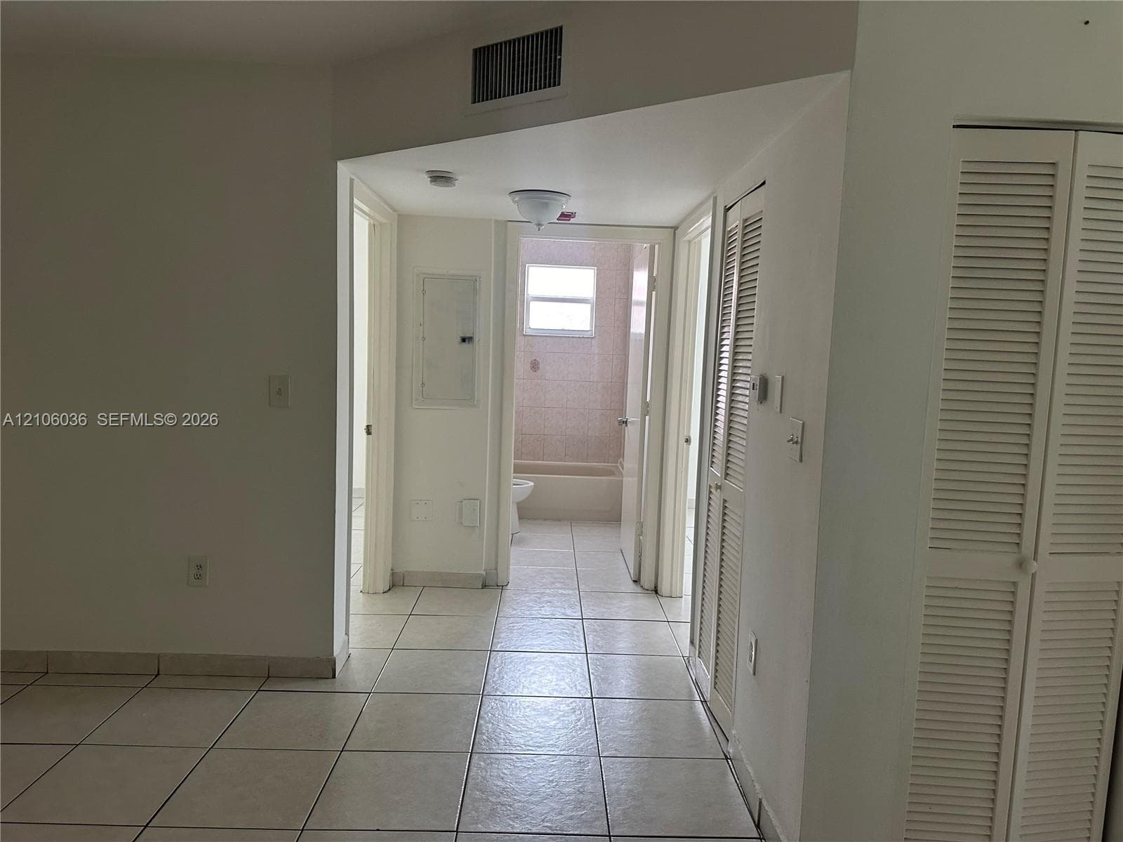 Ceramic tile flooring, louvered bi-fold closet doors, and flush-mount lighting fixture