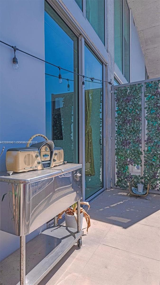 Covered balcony featuring floor-to-ceiling glass paneling and a vertical decorative privacy screen