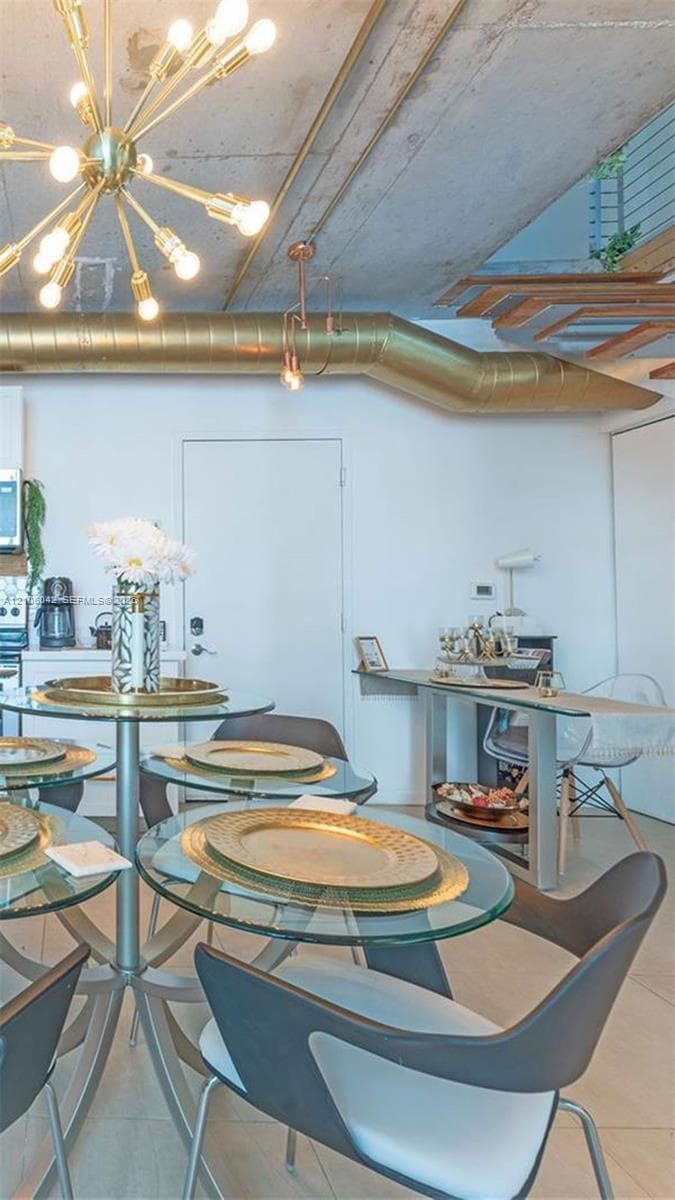 Industrial-style interior featuring exposed concrete ceilings, metallic ductwork, a multi-bulb Sputnik-style chandelier, and large-format tile flooring