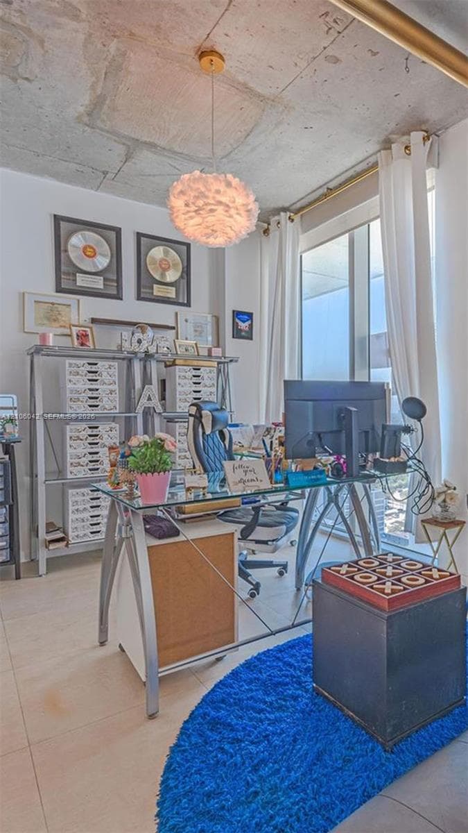 Exposed concrete ceiling, large-format tile flooring, and floor-to-ceiling windows featuring integrated curtain track