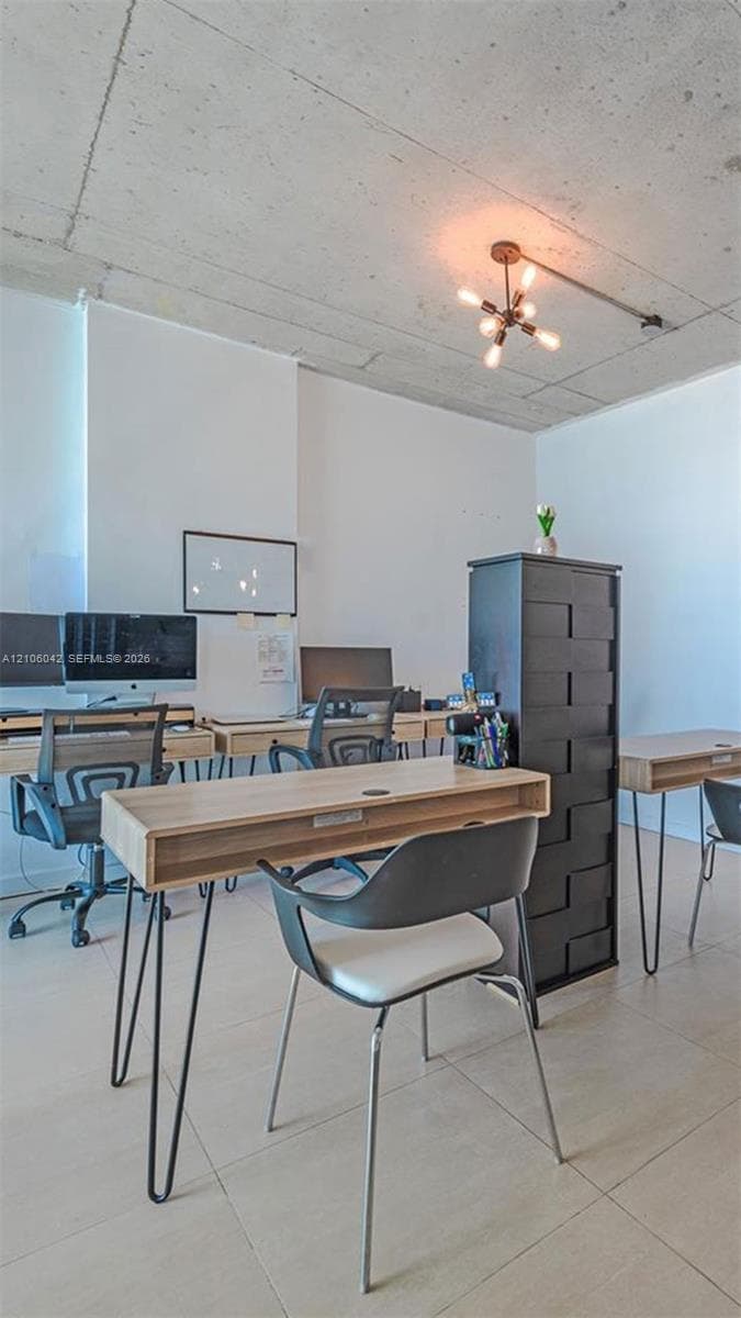 Industrial-style room featuring a raw concrete ceiling, ceramic tile flooring, and a multi-bulb geometric ceiling fixture