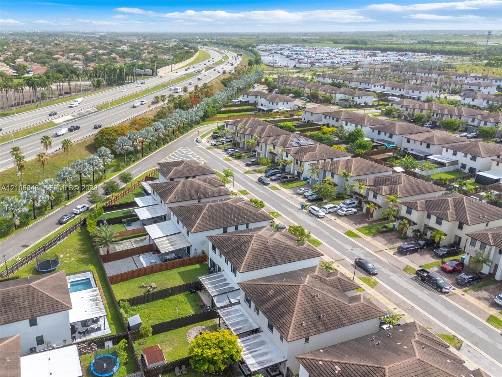 Aerial perspective of a residential neighborhood featuring multi-story homes with hipped tile roofing and enclosed rear yards