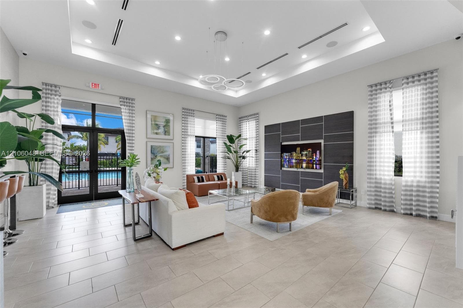 Tray ceiling with recessed lighting, large-format tile flooring, oversized windows, and a structured panel wall feature