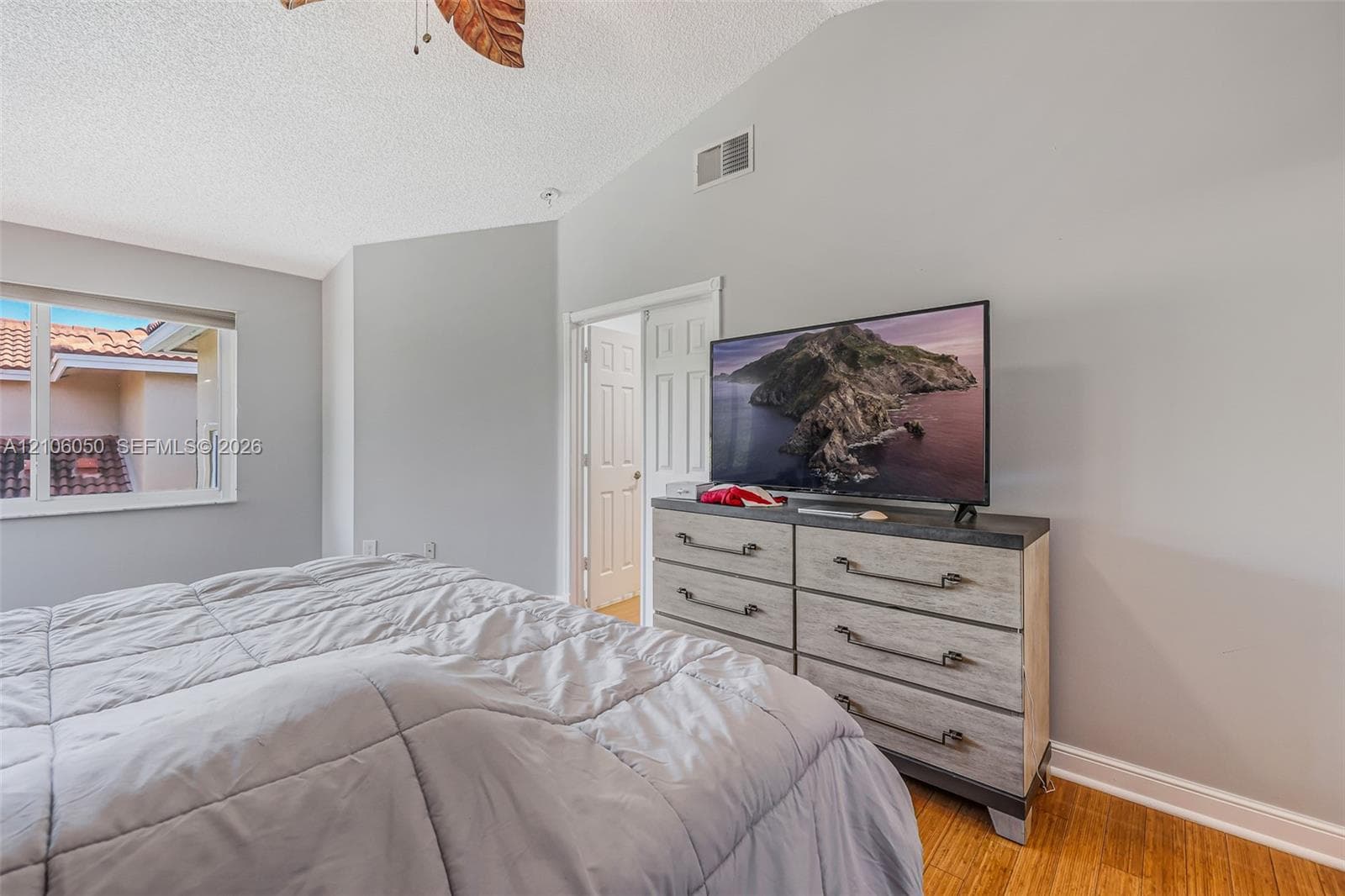 Vaulted ceilings, wood-finish flooring, and white interior doors