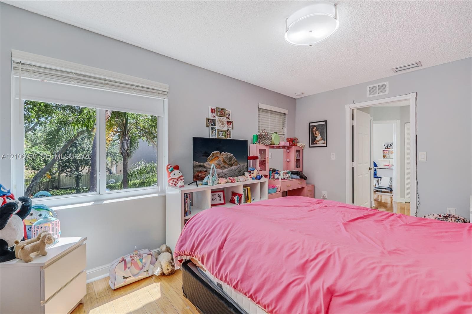 Bedroom featuring wood-finish flooring, dual-pane windows, and a flush-mount overhead light fixture