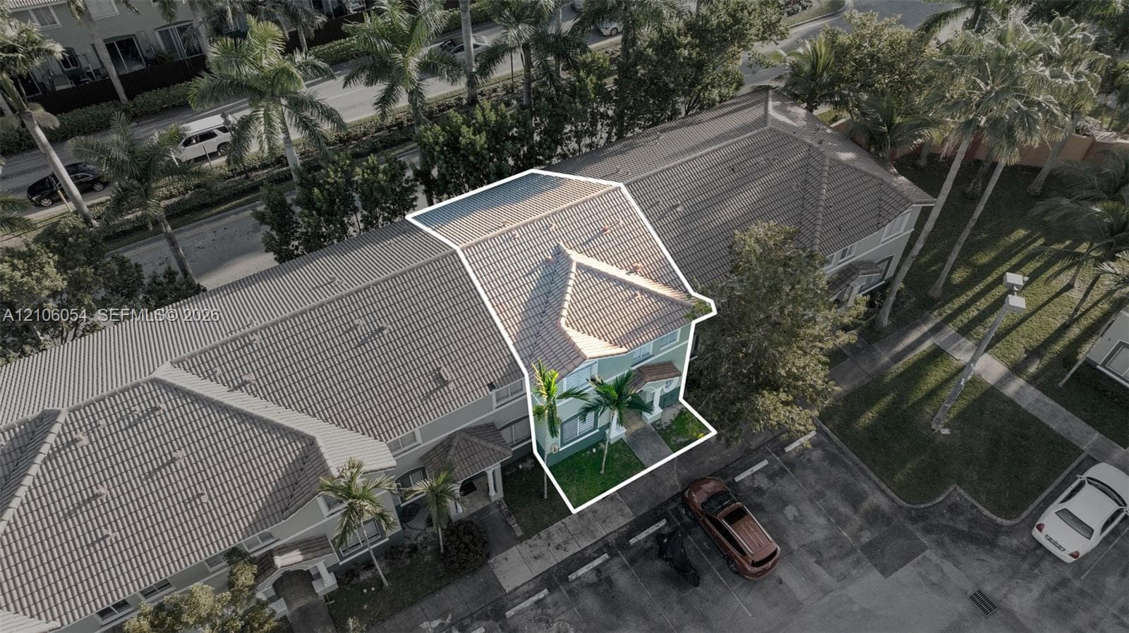 Multi-level townhouse featuring a tiled roof and landscaped exterior grounds