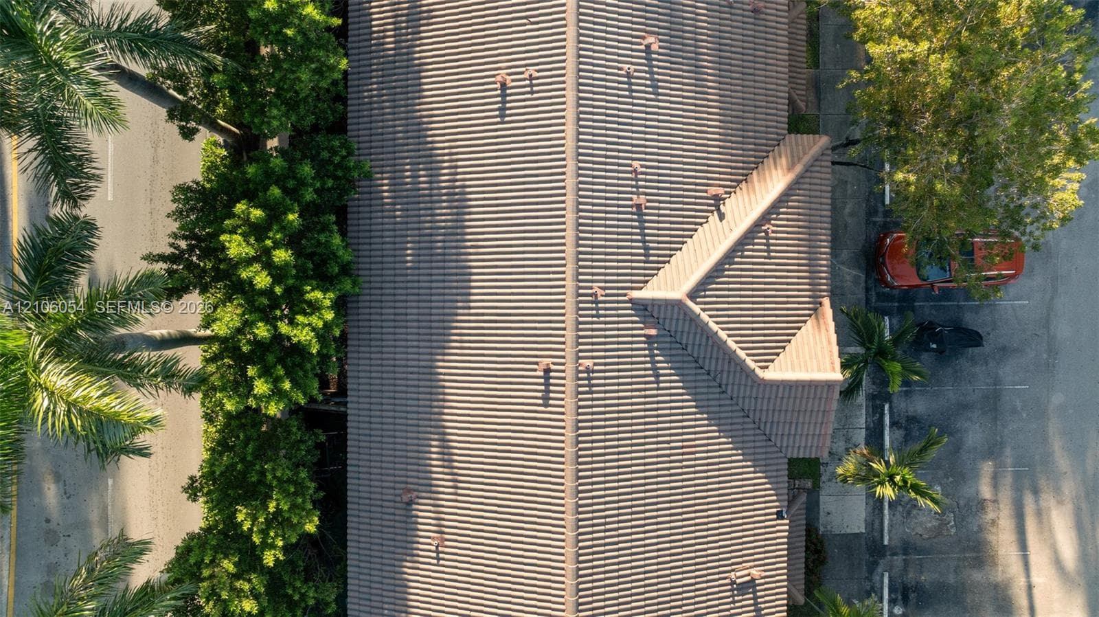Aerial view featuring a multi-pitched roof with neutral-toned tile roofing
