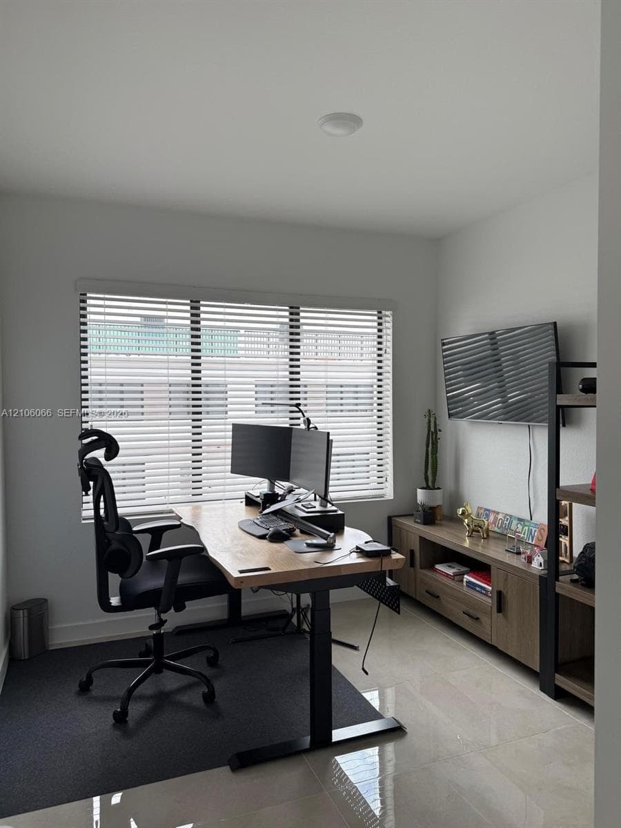 Neutral wall finishes, polished tile flooring, and a window with horizontal blinds