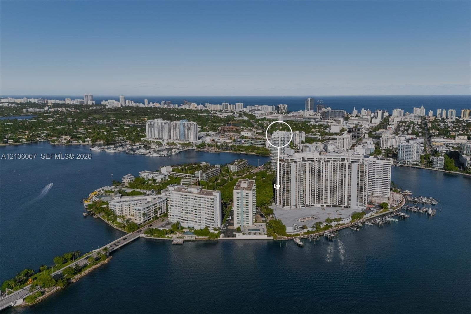 Aerial perspective of a high-rise waterfront condominium complex featuring extensive water frontage, dockage, proximity to ocean waters, and a peninsula setting