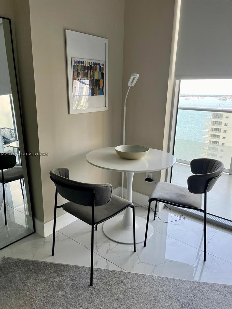 Large-format stone-tile flooring, floor-to-ceiling windows, and glass-railing balcony