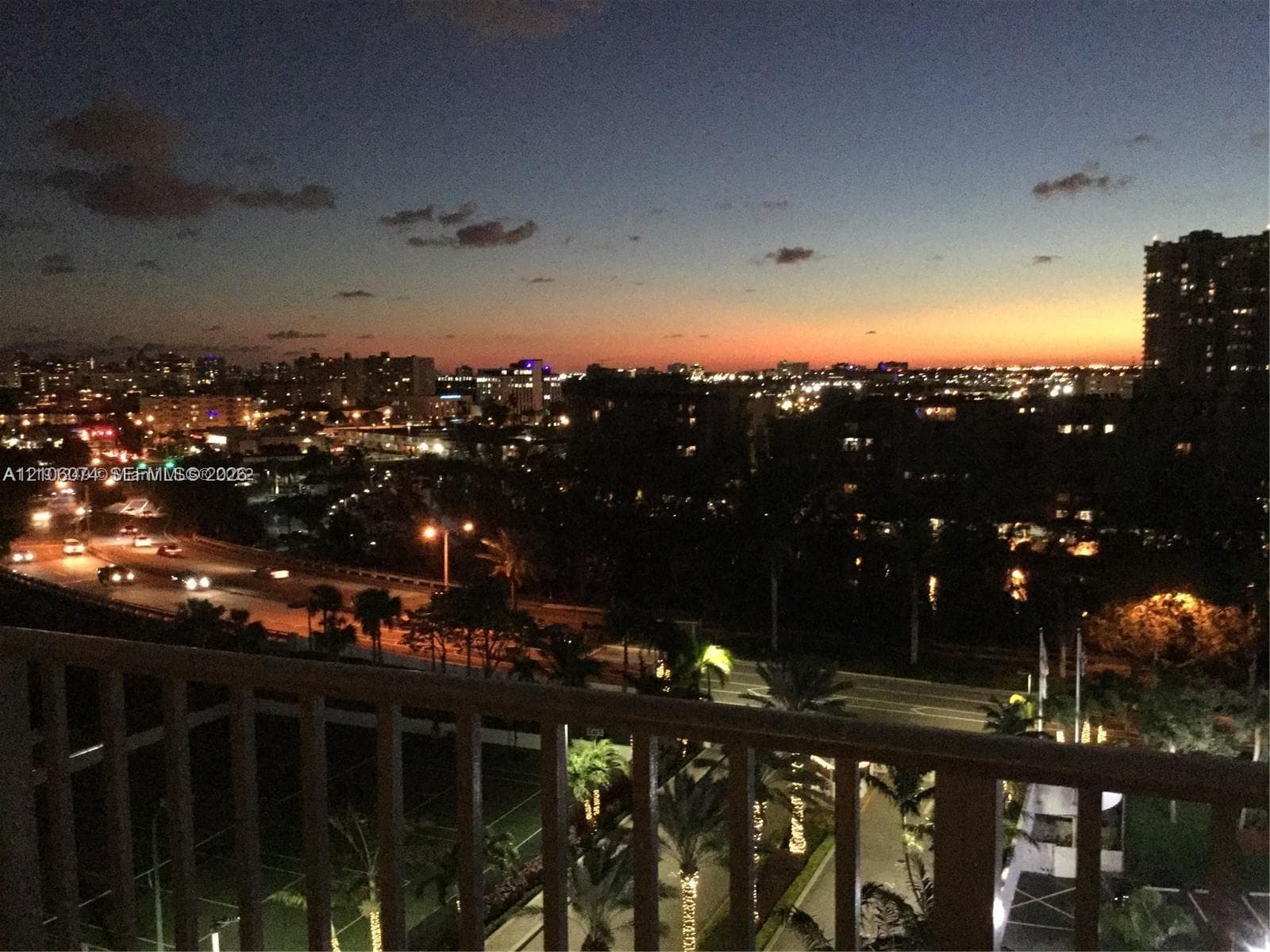 Balcony featuring metal railing and expansive city skyline backdrop