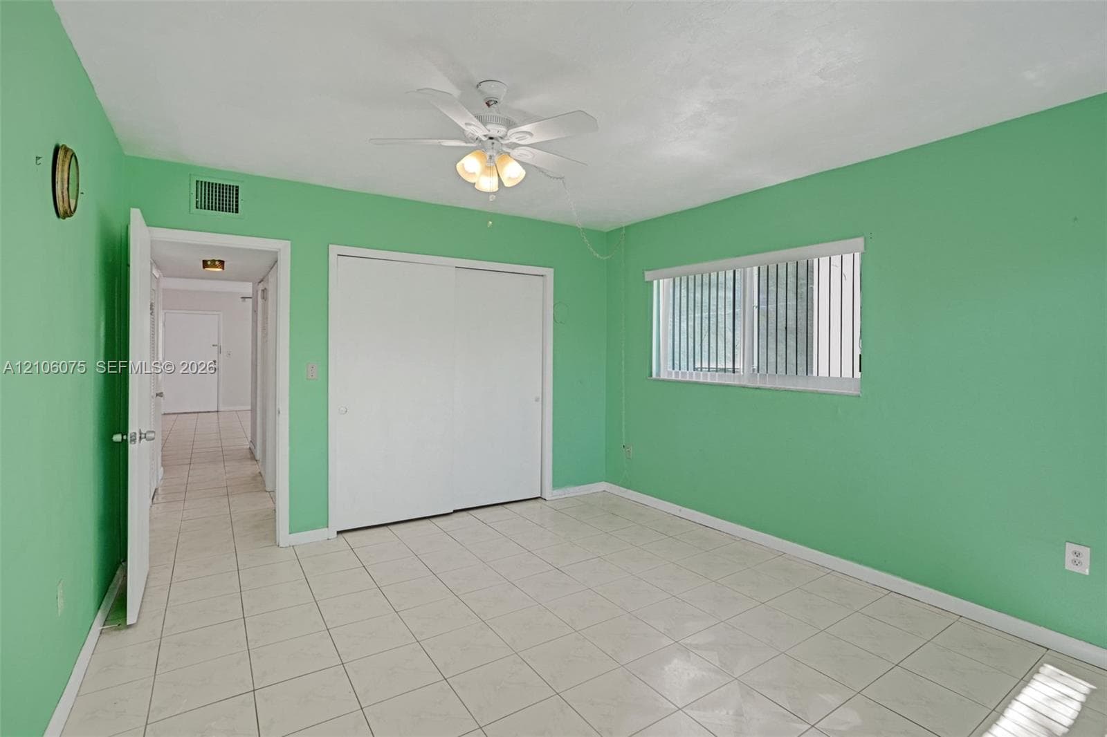 Tile flooring, ceiling fan with integrated lighting, and sliding-door closet