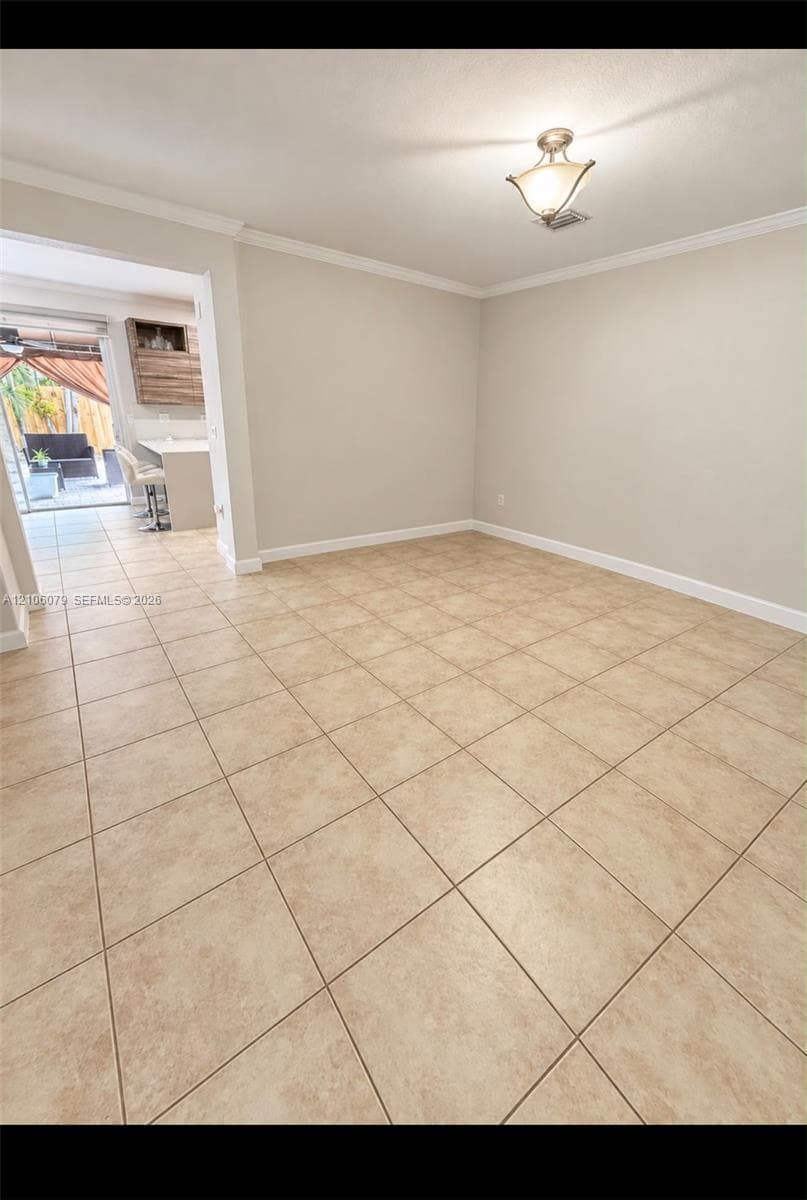 Ceramic tile flooring throughout with crown molding and a flush-mount geometric ceiling light fixture