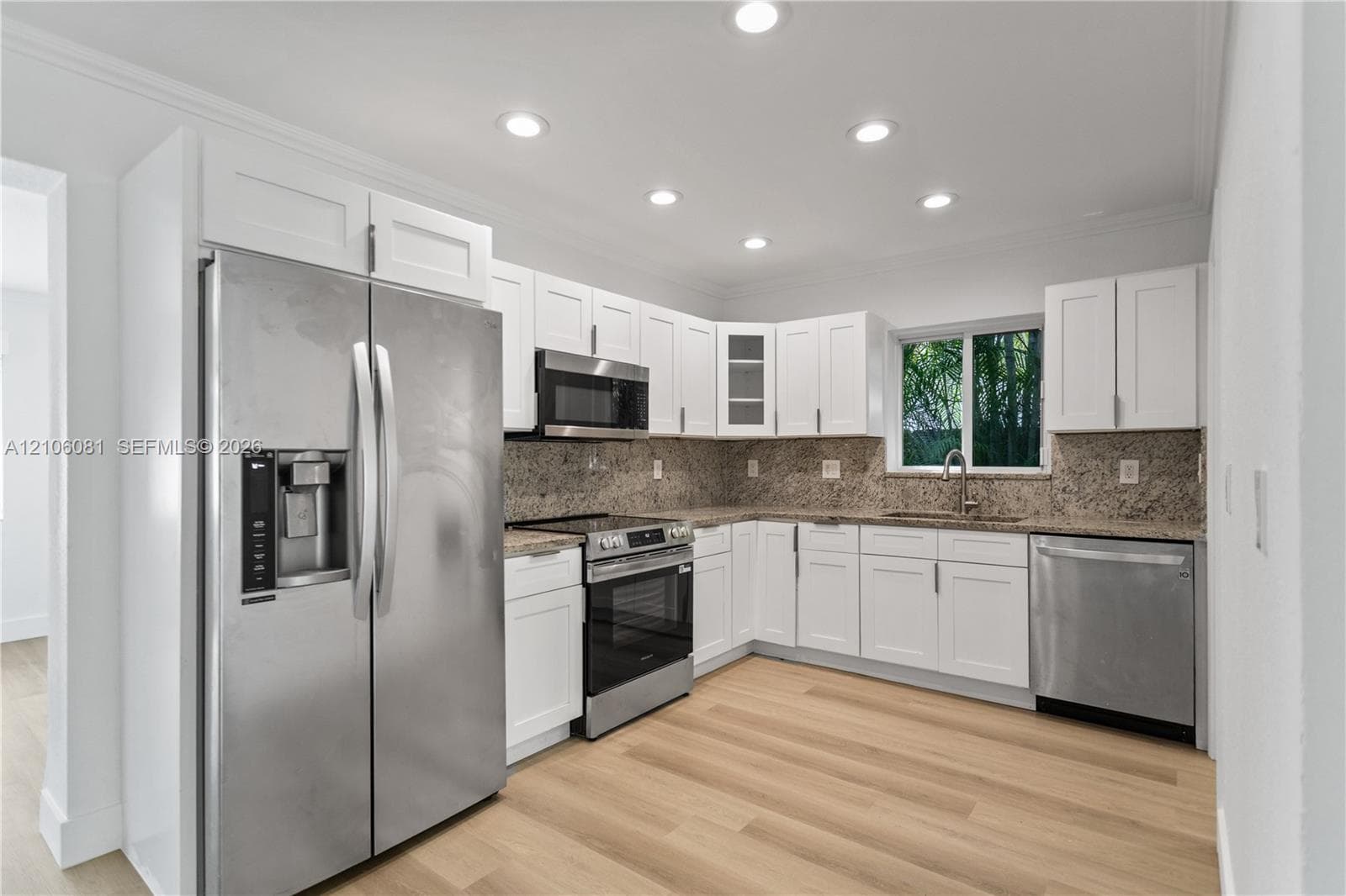 Kitchen featuring white cabinetry, stone countertops, stainless steel appliances, recessed lighting, and wood-finish flooring