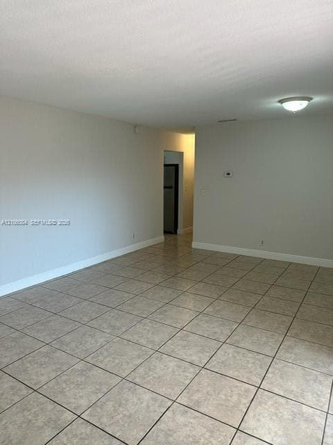 Neutral-toned interior space featuring tile flooring and a ceiling-mounted light fixture