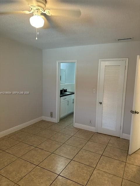 Ceramic tile flooring, ceiling fan with integrated lighting, and louvered closet door