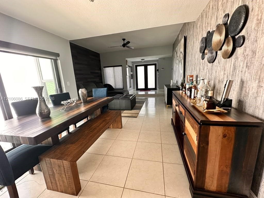 Large-format tile flooring, textured accent wall covering, horizontal wood-plank feature wall, and dual-entry front doors